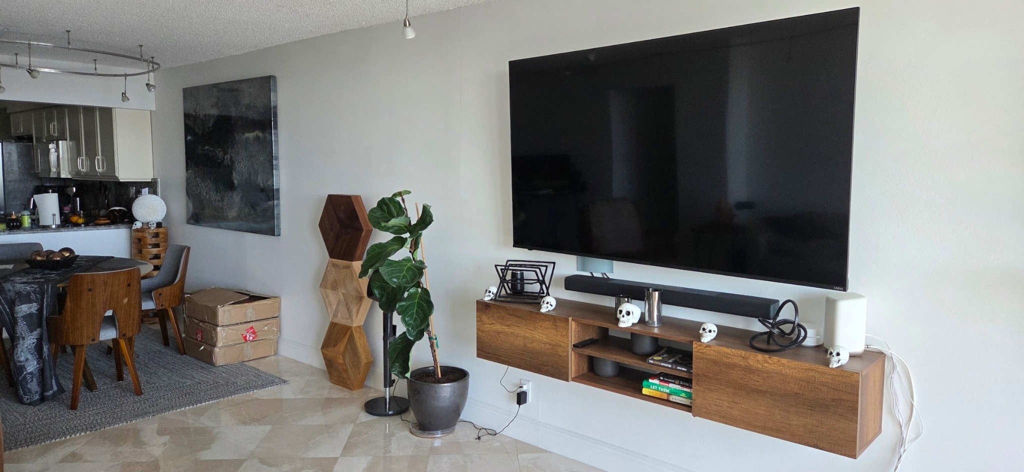 Wall-mounted TV and soundbar above a walnut console